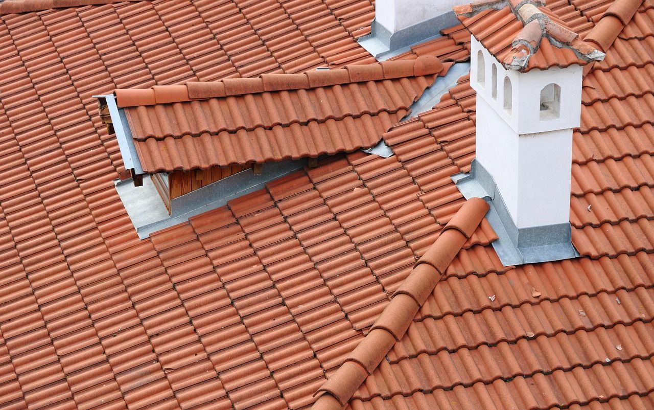 Cheminée et ventilation raccordées à une toiture en tuiles